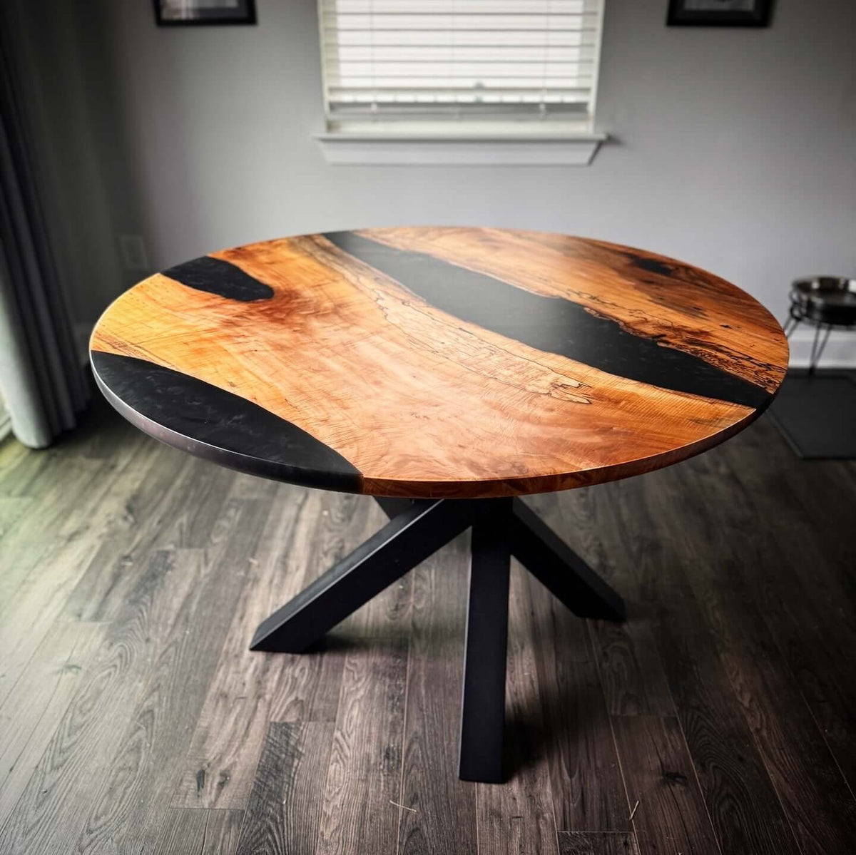 Modern round epoxy river table with stunning wood grain design in a stylish room setting, featuring a durable epoxy finish.