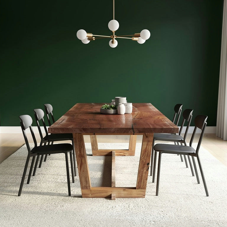 Dining room with a wooden table and chairs against a green wall.