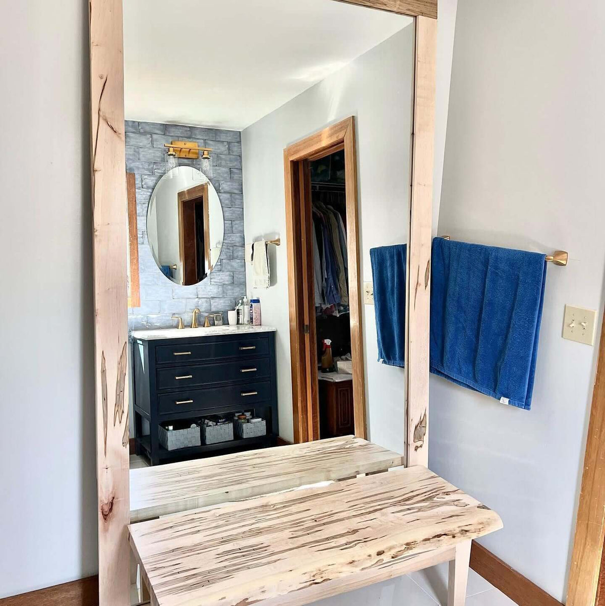 Standing wooden framed mirror enhancing bathroom space with natural elegance and style.