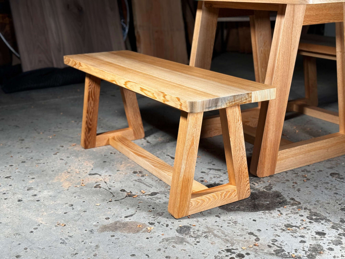 Wooden bench with a modern tapered leg design, perfect for kitchen nooks or patio dining, matches the Newman kitchen table set.