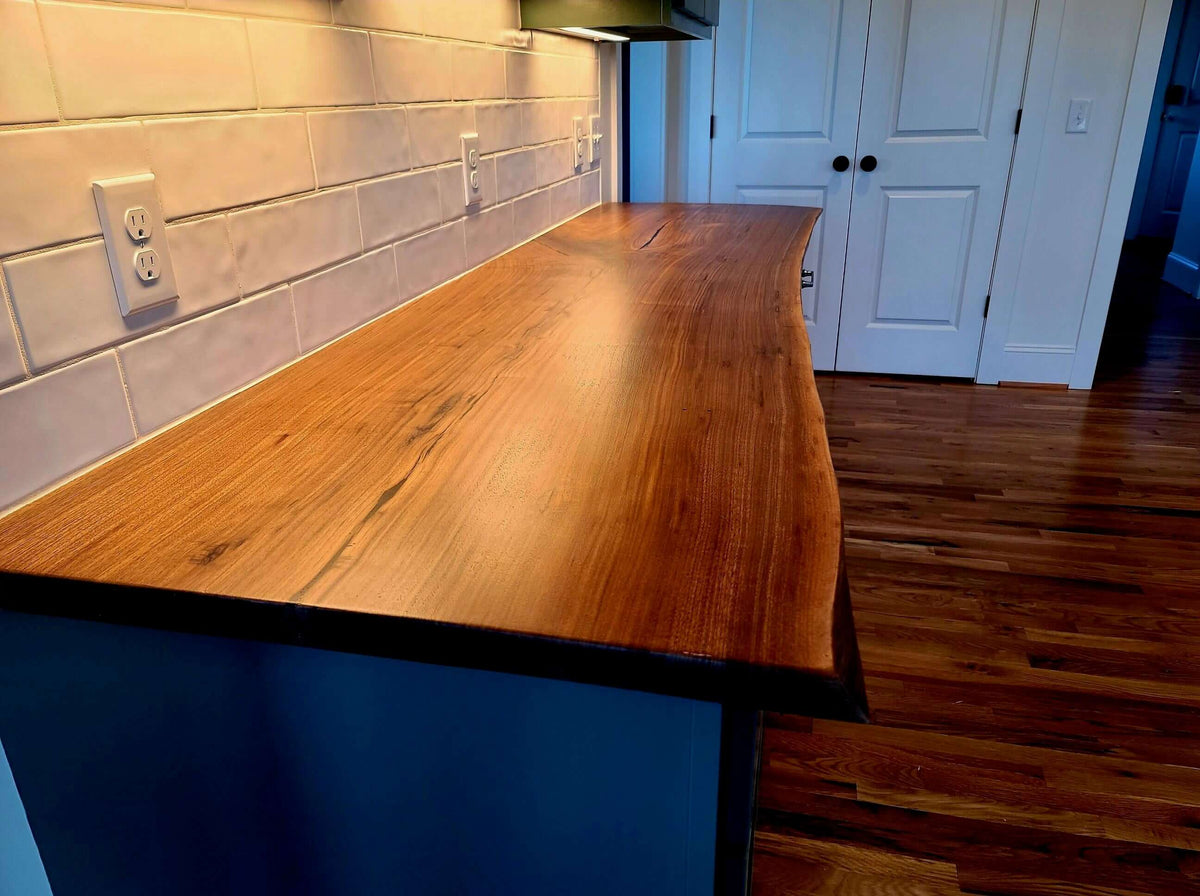 Live edge wood countertop with natural grain and unique edge in a modern kitchen setting.
