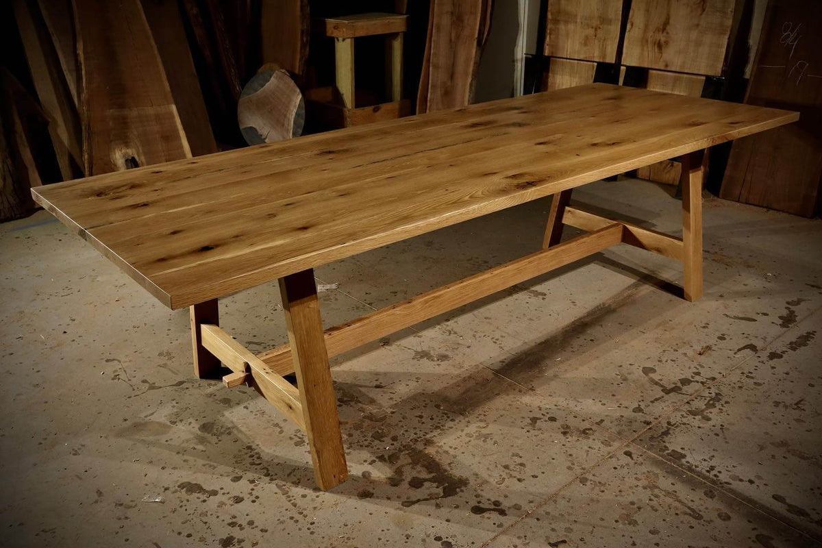 Rustic farmhouse trestle table made of solid wood, showcasing elegance and durability, perfect as a gathering centerpiece.