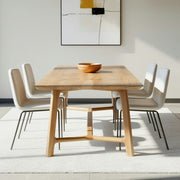 Dining area with wooden table and chairs, abstract art on the wall.