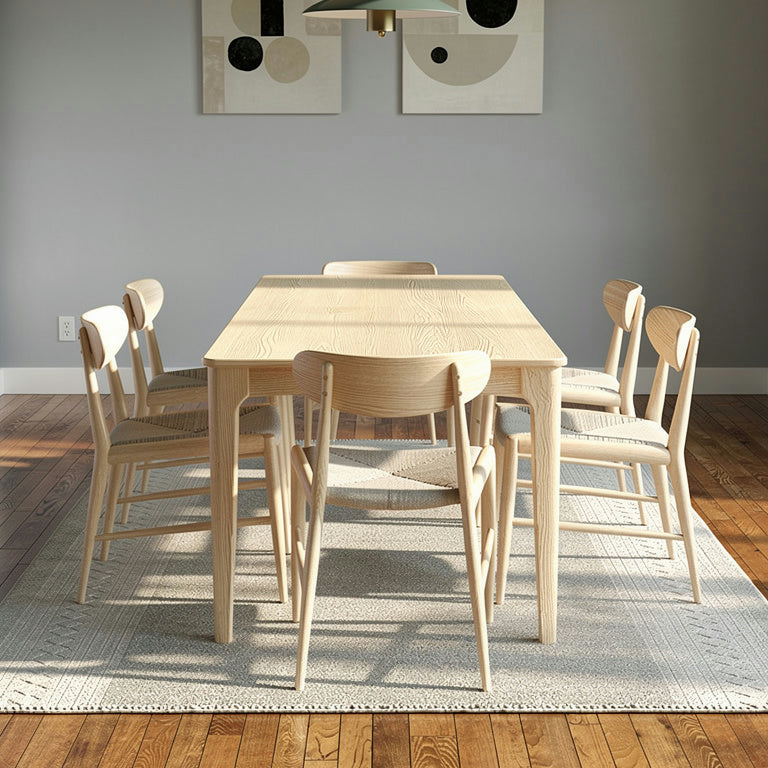 Dining area with wooden table and chairs against a gray wall.